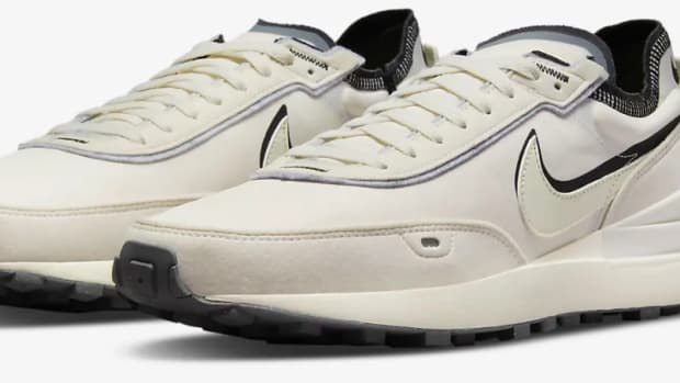 View of tan and black Nike shoes.